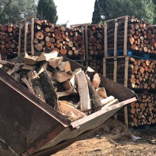 Palettes de bois de chauffage empilées, contenant des bûches de bois sec prêtes à être livrées pour un usage immédiat.